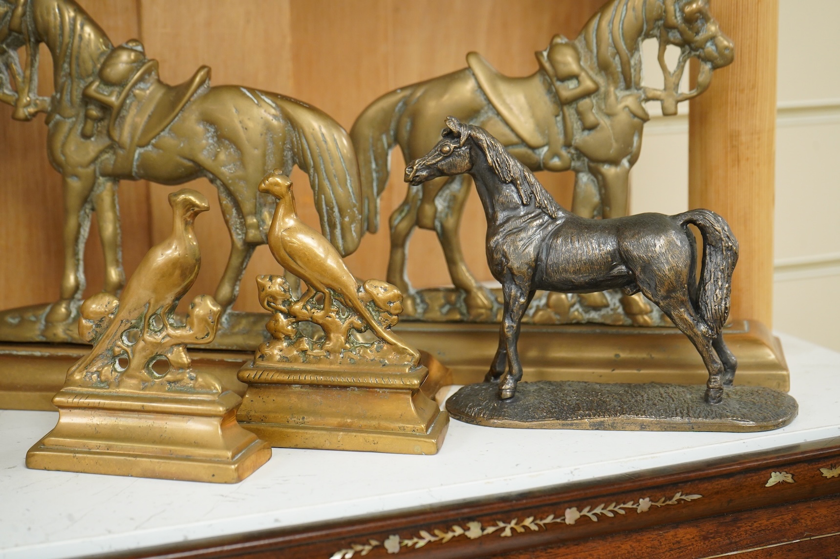 A bronze figure of a horse, two pairs of brass doorstops and a similar pair of candlesticks, 25cm